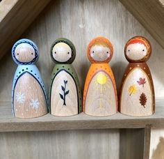 four wooden dolls sitting on top of a shelf