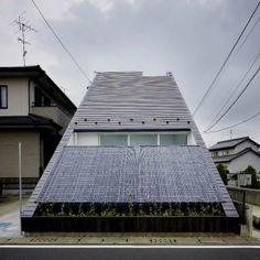 a house with a roof that has a solar panel on the top and plants growing out of it