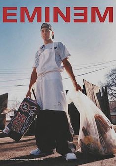 a man is holding two bags and standing in the street