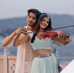 a man and woman are playing violin together