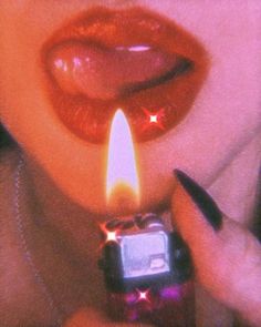 a woman holding a lighter in front of her face with red lipstick and stars on it