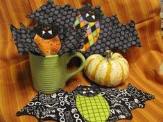 two pumpkins, an orange bat and some black fabric