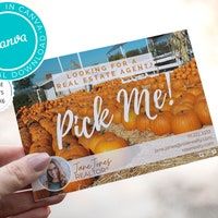 a person holding up a card with the words pick me on it in front of pumpkins