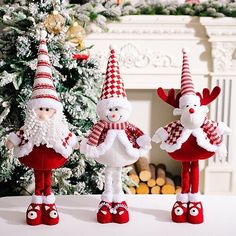 three red and white christmas gnomes sitting on top of a table