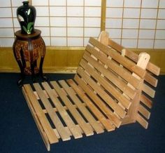 a bed made out of wooden slats next to a vase