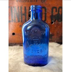 a blue glass bottle sitting on top of a fur rug