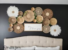 a bed with white pillows and wicker decorations on the wall