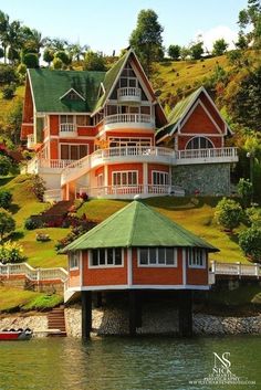 a red house on top of a green hill