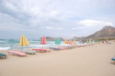 many beach chairs and umbrellas are lined up on the beach