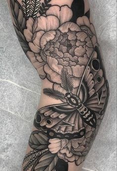 a woman's arm with a butterfly and flowers on it