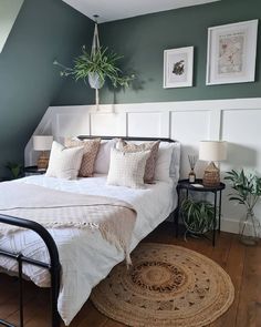 a bedroom with green walls, white bedding and pillows on the bottom half of the bed