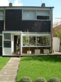 the house is black with white trim and windows on each side that are open to let in natural light