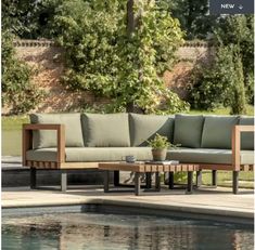 a couch sitting on top of a wooden table next to a pool