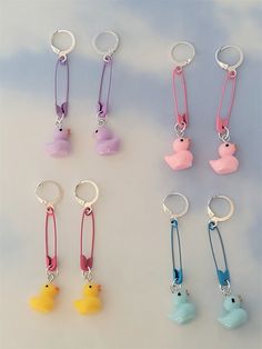 six keychains with different colored rubber ducks attached to them, on a white surface