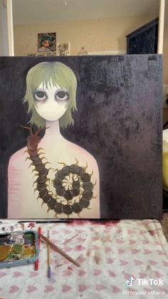 a painting of a woman with green hair holding a snake in her hand, sitting on a table