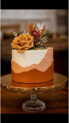 a close up of a cake on a plate with flowers and greenery in the top