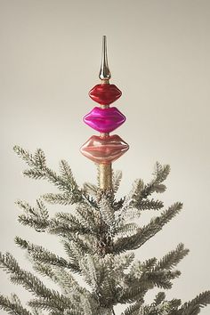 a christmas tree with three colorful ornaments hanging from it's top and bottom branches