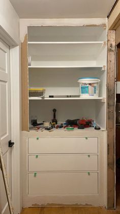 an unfinished room with shelves and tools on the floor, including paintbrushes and other items