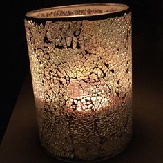 a candle that is lit up in the dark with some rocks on it's side