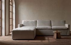 a white couch sitting on top of a hard wood floor next to a wooden table