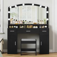 a black vanity with lights and stool in front of it