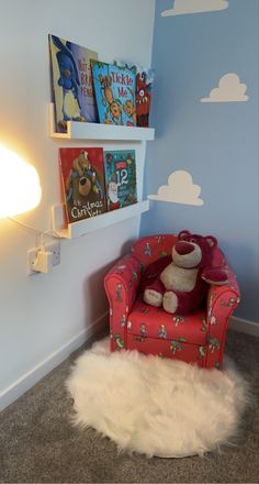 a red chair sitting on top of a carpet covered floor next to a book shelf