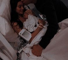 a man and woman laying in bed with an iv drip attached to their chests