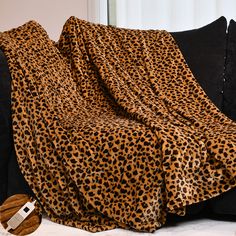 a leopard print blanket sitting on top of a couch