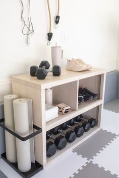 a white shelf with some black and white items on it next to a pair of dumbbells