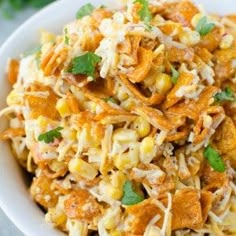 a white bowl filled with corn salad and garnished with cilantro leaves