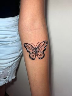 a woman's arm with a butterfly tattoo on the left side of her body