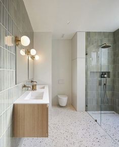 a bathroom with two sinks, a toilet and a walk in shower next to each other