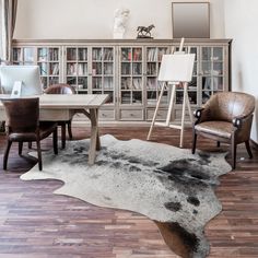 a living room filled with furniture and a bookcase full of books on top of a hard wood floor