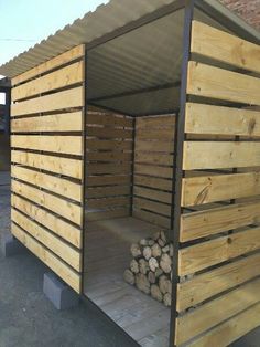 a wooden shelter with logs stacked in it