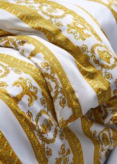 the gold and white bedding is made up of different types of patterns on it