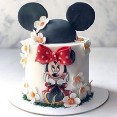 a mickey mouse cake is decorated with flowers