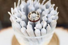 a wedding ring sitting on top of a vase filled with white flowers