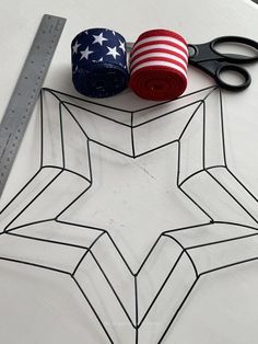 a pair of scissors, tape and an american flag star on top of a table