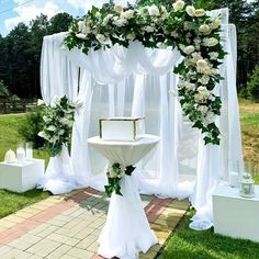 an outdoor wedding setup with white flowers and greenery