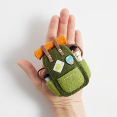 a hand holding a small green and orange cell phone case in it's palm