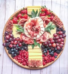 a platter with fruit, cheese and meats on it