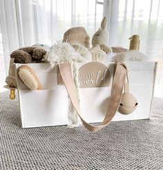 a white box filled with stuffed animals on top of a carpeted floor next to a window