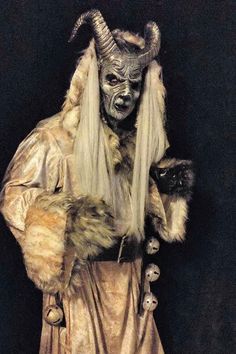 a man dressed up as a demon with long hair and horns