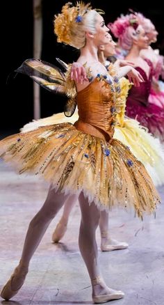 three ballerinas in tutus and dresses with feathers on them