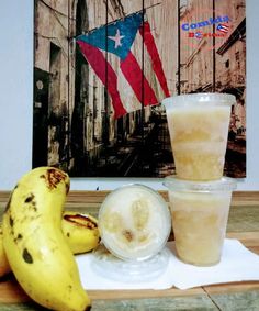 there is a banana and two cups on the table next to each other with an american flag in the background