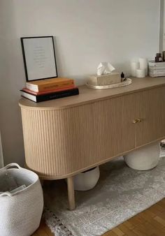 a white vase sitting on top of a wooden cabinet