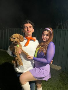 a man and woman are holding a dog