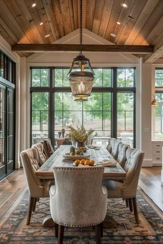 a dining room table with chairs and a chandelier hanging from the ceiling above it