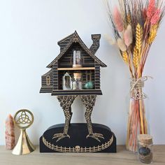 a wooden bird house sitting on top of a table next to vases and other items