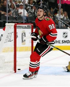 a hockey player is standing in front of the net